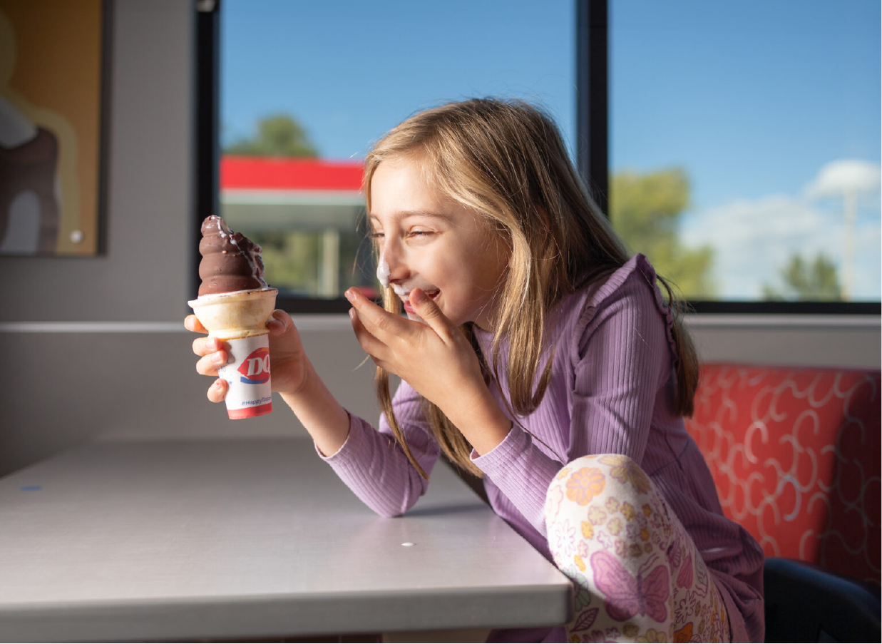 Smiling blonde girl with ice cream on her nose